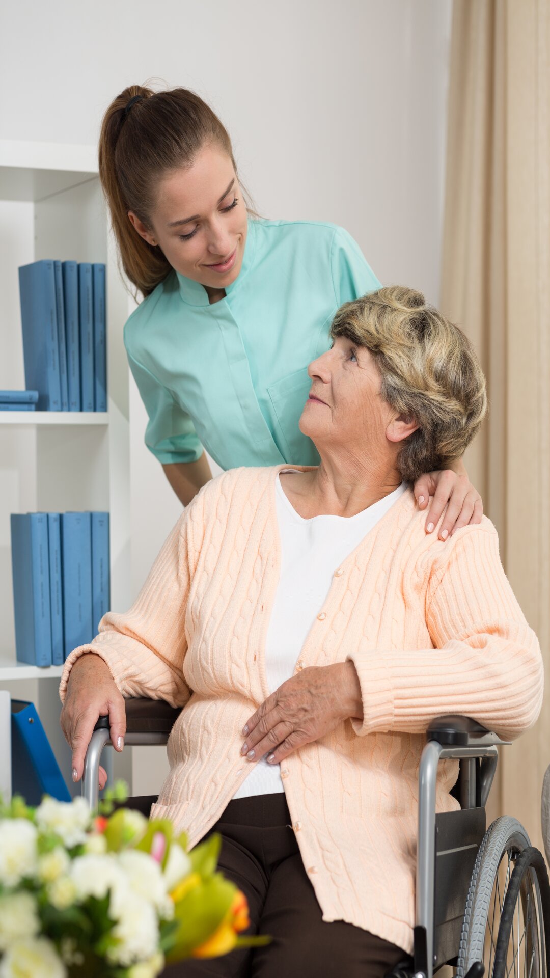 Disabled woman talking with nurse in rest home